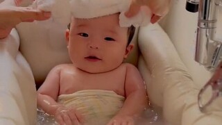 Bayi kecil yang dengan patuh mengikuti kemauan ibunya saat mandi, tidak menangis, tidak merengek, da