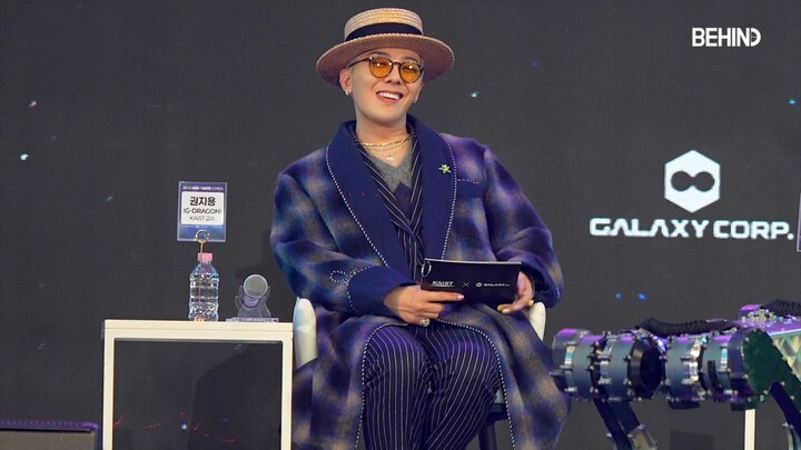 G-Dragon stifles his laughter as he watches the robotic dog dance—so funny he can’t laugh, you know?