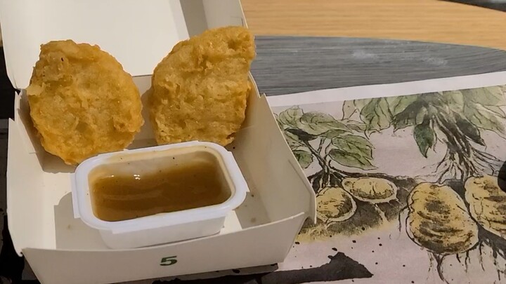 Two pieces of chicken McNuggets that were overwhelmed by the sweet and sour sauce