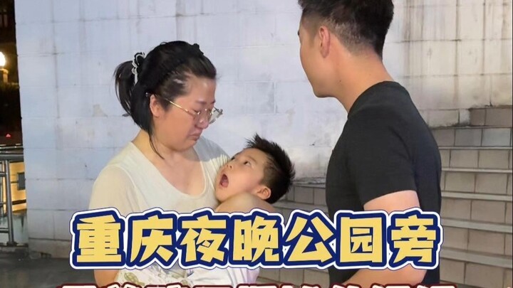 A mom sets up a stall with her kid by the park at night in Chongqing.