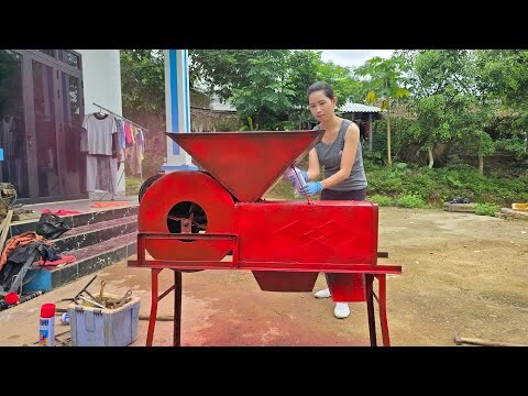 The girl repairs and restores the rice fanning machine and repaints it with a new layer of paint