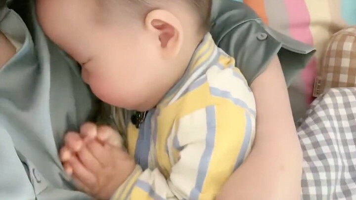 Bayi manja yang tenang bersandar di pelukan ibunya, si bayi manusia yang semakin lama dipelihara jus