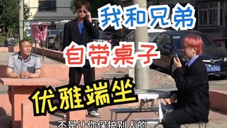 我和兄弟自带桌子优雅的坐着 离大哥1米远 给大哥打电话