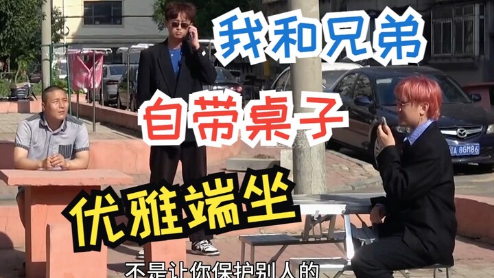 我和兄弟自带桌子优雅的坐着 离大哥1米远 给大哥打电话