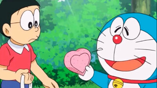Nobita took the heart-shaped clay from the blue fat man, raised it up and was about to observe the r