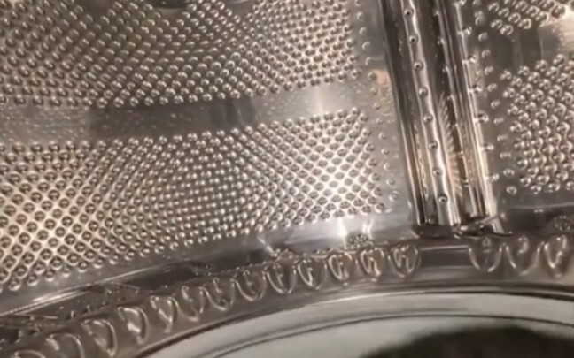 Một chàng trai trải nghiệm máy giặt