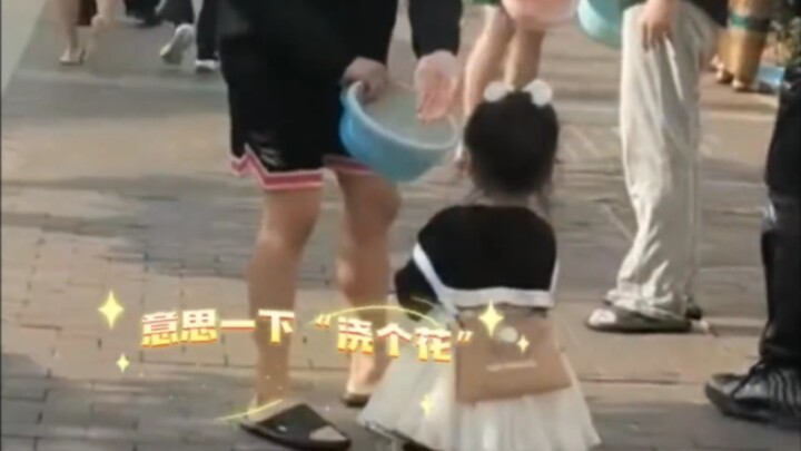 خلال مهرجان رش الماء، طاردت فتاة صغيرة مجموعة من الأولاد ورشت عليهم الماء. استدار الأولاد ورشّوا الم