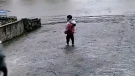 Cute kid bounces and jumps on the way to school as the school bus zooms past right outside the door.