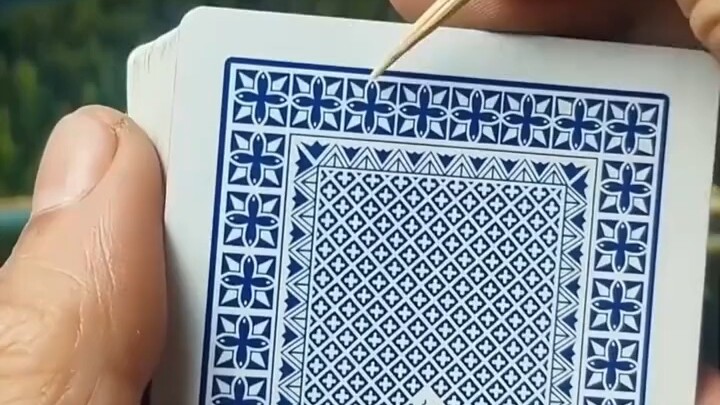 A man can easily guess the card number by noticing details on the back of the playing cards.
