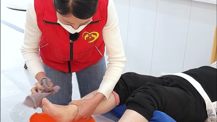 مساعدة المسن المصاب بالشلل النصفي على غسل قدميه في السرير