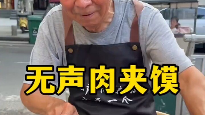 On a street in Zhoukou, an elderly vendor runs a silent roujiamo stall; with such warmth and cheerfu