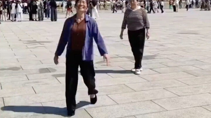 An elderly woman dances “On the Golden Mountain of Beijing” in Tiananmen Square, and her moves are s