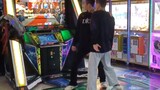 Saya melihat dua orang melakukan Trouble Maker di arcade.