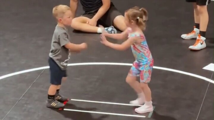 A little girl keeps knocking out her opponents one after another on the wrestling mat. Tiny stature,
