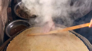 The ancient custom is tenaciously preserved, the griddle is heated, the batter is evenly spread, the