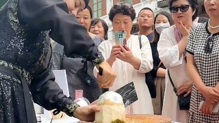 好奇的游客们，没有见过砍椰子蛋。