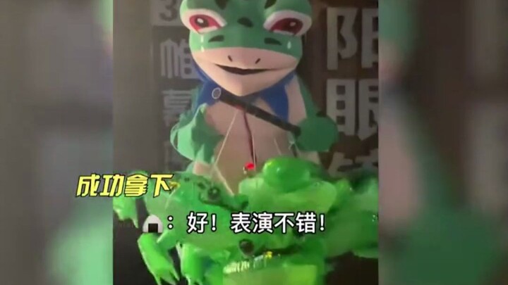 The frog doll has become another species on the streets, exuding a clear‑eyed kind of foolishness.