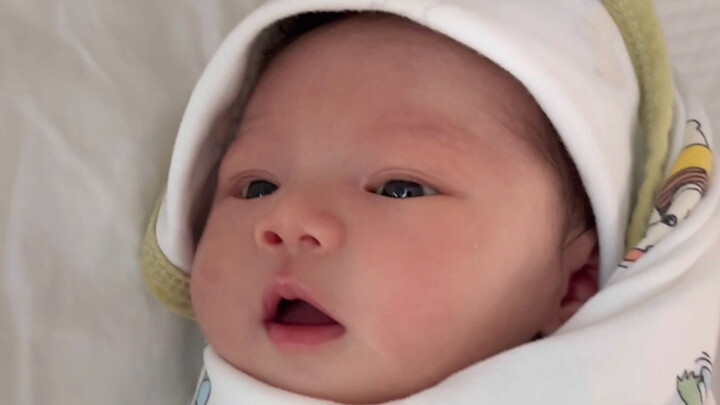 The baby, all wrapped up like a little roll, won’t stay wrapped for long!