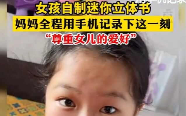 A girl makes a miniature pop-up book, and her mom records the whole moment on her phone...