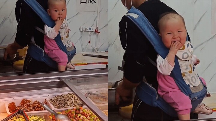 Một chủ cửa hàng đồ nguội ở Bắc Kinh cõng đứa con 2 tuổi trên lưng khi đi làm, hành động dễ thương v