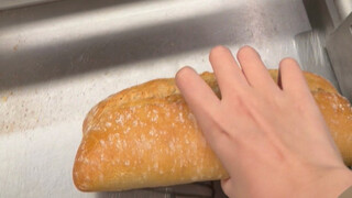 Dequ Liuzi immersively devours a €0.59 loaf of bread.