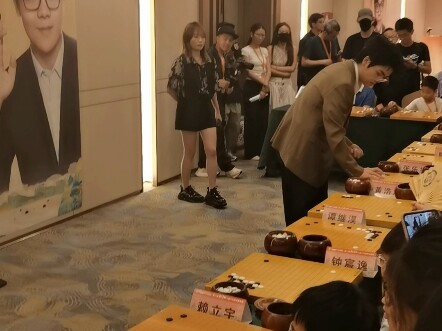 In the Ke Jie Cup coaching session, Ke Jie plays chess with young children.