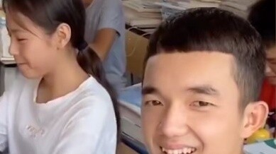 Một cậu bé đưa cho cô gái ngồi cùng bàn một miếng thịt. Khi cô giáo nhìn thấy, phản ứng của cậu ấy c