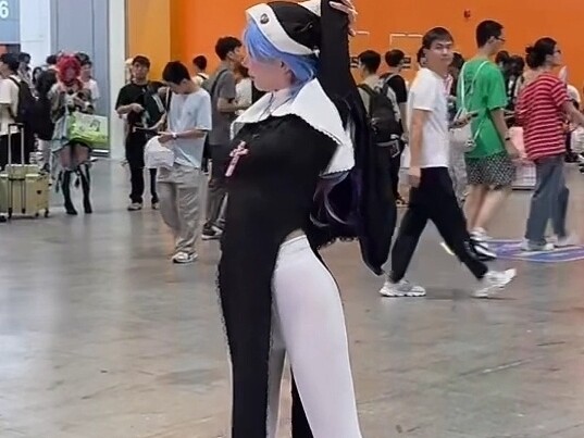 Bunny-Hooped Nun Cosplay Showcasing Outfits at a Comic Convention