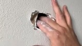 he fixes a hole on the wall