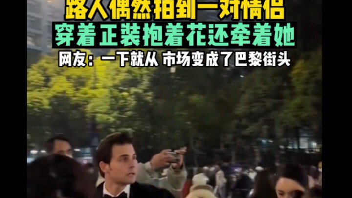 คนเดินถนนบังเอิญถ่ายติดคู่รักคู่หนึ่ง ทั้งแต่งตัวสุภาพถือดอกไม้และจับมือกัน ชาวเน็ตบอก: แค่แวบเดียวจ