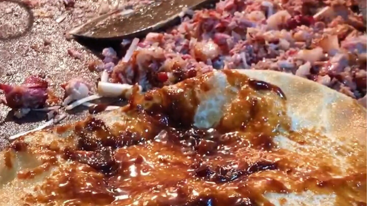 现炸的油饼刷上酱，抓一大把葱卷上肥瘦带皮的熏肉，13元一个排队买，吃不饱但能解馋