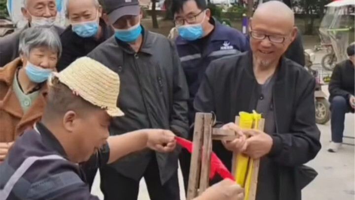 Middle-aged man performs street magic: a silk scarf passes through a chair!