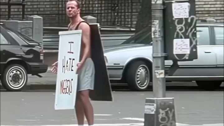 رجل يحمل لافتة عنصرية يقف في حي يسكنه السود