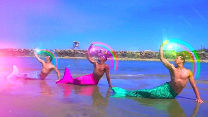 Cool special effects! Three guys transform into mermaids and dance wildly on the beach to Ariana Gra