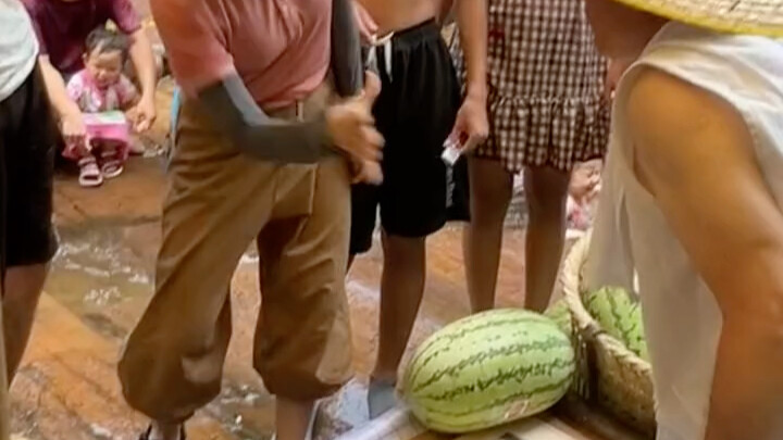 جدٌّ من لويانغ يعرض بطيخًا ويتحدى المارة في لعبة “دينغ كه”؛ من يخسر يحصل على البطيخ مجانًا، ولا يطلب