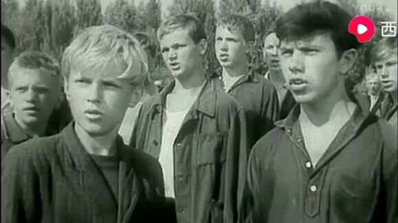 Tentara Soviet dan warga sipil yang akan dibawa ke kamp konsentrasi menyanyikan Internationale bersa