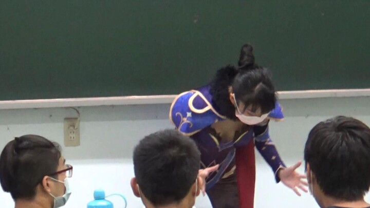 Guru klub kampusmu mengenakan kostum Genshin Impact untuk menunjukkan aksi spesialnya kepadamu