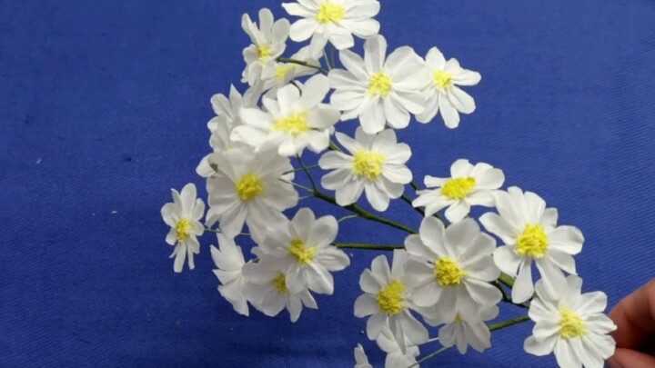 Tutorial for making white daisies with paper towels. The plain colors are different under the fence,