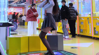 The girl in the knee-length black silk pleated skirt dances on the hot issue, and the arcade is gett