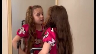 فتاة مصابة بالتوحد، فيرناندا، تغني أغنية شعبية برازيلية بعنوان "على جانب الطريق" أمام المرآة، وكأنها