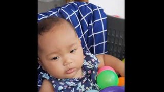 Baby playing ball in basket