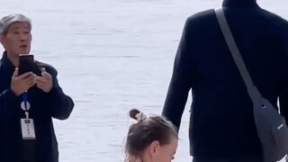 老大爷轮流和外国美女在浅水湾海滩合影