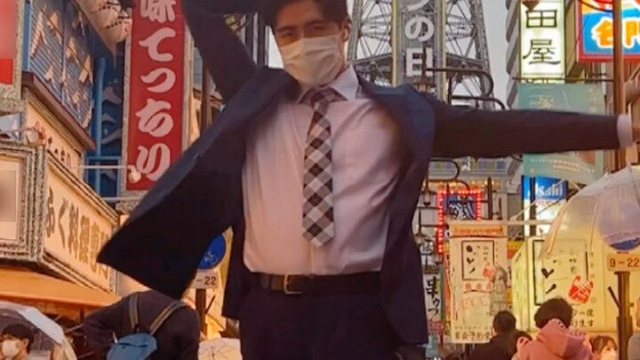 Seorang pria berjas menari di Tsutenkaku, Osaka