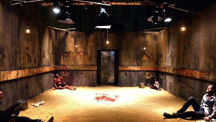 Four people are trapped in a sealed room by a serial killer, fed raw meat and live insects daily, an