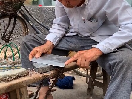 Cụ ông hơn 80 tuổi này là một thợ mài dao; gương mặt già nua và tấm lưng còng đã chứng kiến cả một đ