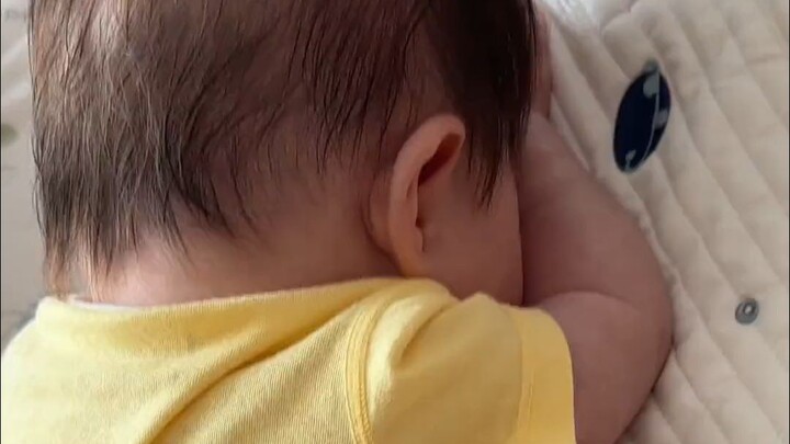 The little crybaby lies on its belly, sobbing heartbreakingly, with tears and snot smudged all over 