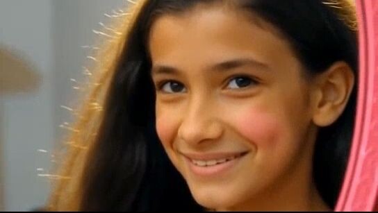 A girl gazes intently at her reflection in the mirror, contempl