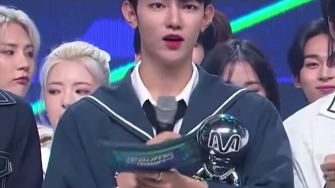 MC Zhang Hao yang membantu senior Jeon Jungkook memegang satu buah trofi!