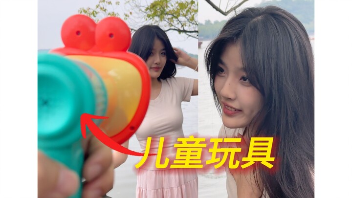 Đưa đồ chơi cho cô gái để chụp ảnh