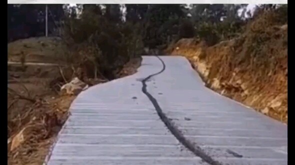 Man rides bike on wet cement road, leaving a long track behind; complains: Why isn't there a warning